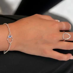 Bracelet chaîne argent Main de Fatma Hamsa avec œil bleu porté au poignet - bijou artisanal fait main