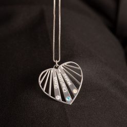 Collier cœur famille personnalisé pour maman en argent 925 avec prénoms posé sur un tissu noir