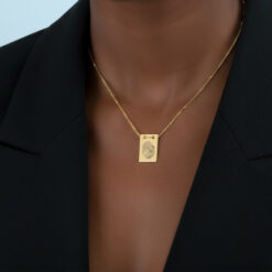 Femme portant un collier plaque avec empreinte digitale gravée, chaîne à billes en acier inoxydable doré pour un look minimaliste et sentimental.